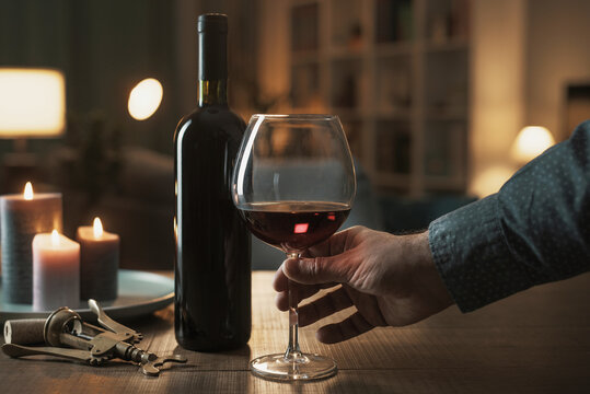 Man drinking a glass of red wine at home