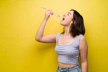 Attractive woman using chopsticks