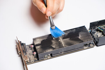 Computer wizard brushes the video card from dust.