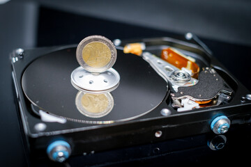 euro coin is standing on an open hard drive