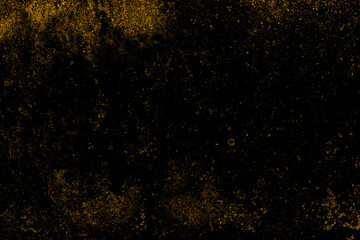 Fototapeta na wymiar Scattered yellow grunge texture on a black concrete wall surface for background
