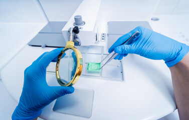 Laboratory assistant works at paraffin wax dispenser tissue embedding machine.