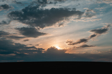 Beautiful sunset with the sun behind the clouds. Clouds and sun.