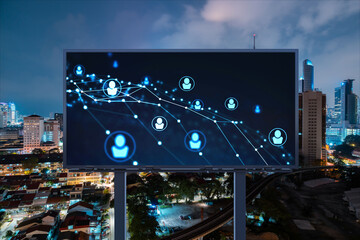 Glowing Social media icons on billboard over night panoramic city view of Kuala Lumpur, Malaysia, Asia. The concept of networking and establishing new connections between people and businesses in KL