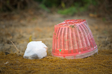 Red basket and gardener's fertilizer bag with natural background.