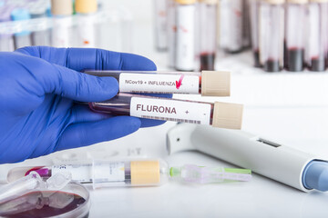 Doctor's hands hold blood samples of the new variant omicron plus flu FLURONA, covid19,...
