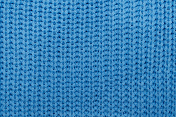 Knitted fabric. Blue knitted rug close-up. Textile texture on a blue background. Detailed warm yarn background. Knit cashmere wool. Natural woolen fabric, a fragment of a sweater. Knitting pattern