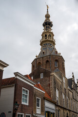 Walking in old Dutch town Zierikzee with old church tower, small houses and streets