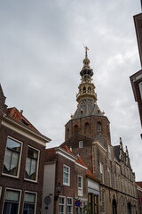 Fototapeta na wymiar Walking in old Dutch town Zierikzee with old church tower, small houses and streets