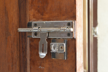 Close up view of wooden door with slide bolt lock.