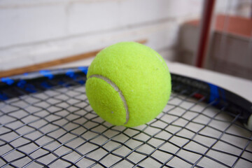 Yellow tennis ball on a paddle racket