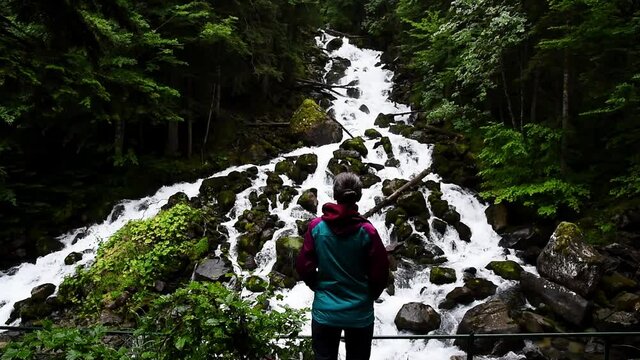 Hiker at amazing waterfall in the mountains. (Uelhs deth Ju&egrave;u, Vall Aran, Spain)