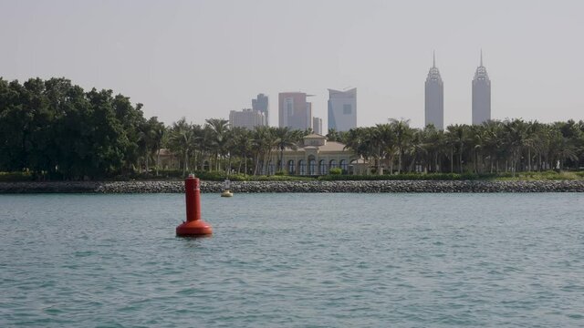 Dubai Island with buildings in the background and speedboat passing
