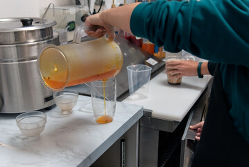 Pouring the first liquid into the cup when preparing a boba for the customer to drink