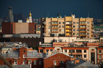 Yellow houses and roofs on the deep grey pre-storm sky. Birds-eye view the center of Moscow Garden...