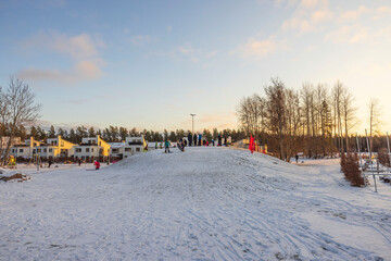 Beautiful view of people on outdoor playground on sunny cold winter day. Sweden.
