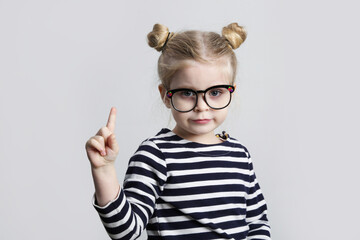 Little nerd pointing finger up, studio shot