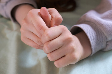 only hands of a teenage child are large, nervously clenched into fists