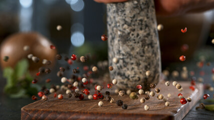 Freeze Motion Shot of Crushing Colored Peppers Balls in Mortar.