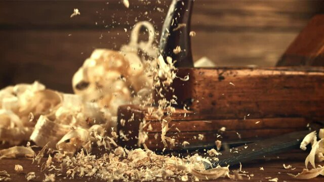 Wooden shavings fall on the table. On a wooden background. Filmed is slow motion 1000 fps. High quality FullHD footage