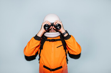 Man with astronaut helmet using binoculars