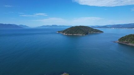 Fototapeta premium Beautiful deserted beach in Ubatuba, São Paulo, Brazil. Atlantic forest, yellow sand and clear sea water. Figueira beach paradise.