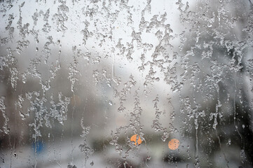 Melting ice running down a window pane,