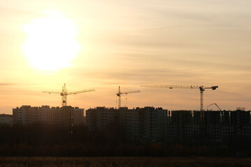 Cranes at the sunset work on the construction of modern resedential district near Tula, Russia