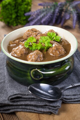 Pork meatballs with noodles in a green bowl.