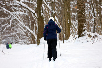 Woman skiing in winter park. Leisure outdoors, female skier walking by snow