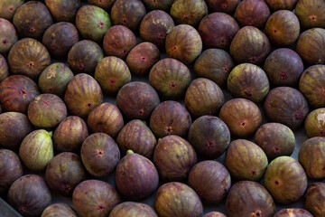 Fresh figs in a box on the market. Dyeic foods and vitamins. Close-up.