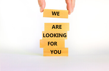 We are looking for you symbol. Wooden blocks with words We are looking for you. Beautiful white background, copy space. Businessman hand. Business, we are looking for you concept.