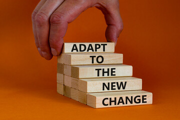 Adapt to the new change symbol. Wooden blocks with words Adapt to the new change on orange...