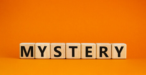 Mystery symbol. The concept word Mystery on wooden cubes. Beautiful orange table, orange...