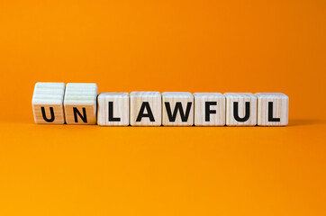Lawful or unlawful symbol. Turned wooden cubes and changed the word unlawful to lawful. Beautiful orange table, orange background, copy space. Business and lawful or unlawful concept.