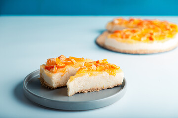 Closeup detail view sliced orange cheesecake or pudding, decorated with riped orange fruit.
