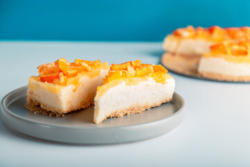 Closeup detail view sliced orange cheesecake or pudding, decorated with riped orange fruit.