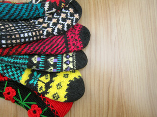       Colorful knitted socks on wooden background.Hand labor    