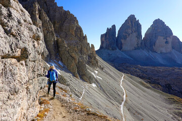 Fototapeta na wymiar Young woman trekking on the via ferrata of Monte Paterno. Adventure activity in Dolomites, Italy
