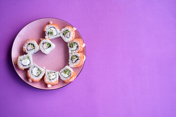Obraz na płótnie Canvas Sushi set in the shape of a heart on very peri background. Valentine day or March 8th food concept.The concept of a romantic dinner at a sushi bar for February 14th.