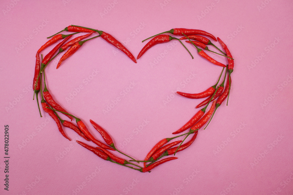 Wall mural red hot chili pepper in the shape of a heart on a pink background. Romantic postcard . Valentine card