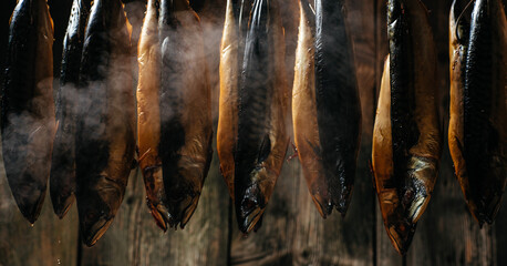 Smoked fish mackerel or scomber in smokehouse. Smoking Process Fish. banner, menu, recipe place for...