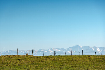 Obraz premium Weidezaun vor verschneiter Alpenkulisse