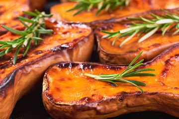 roasted butternut squash with rosemary, food background.