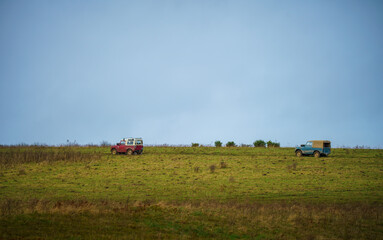 a pair of vintage Land Rover series 2 vehicle driving off-road on Salisbury Plain UK