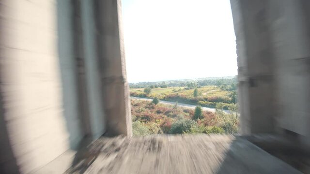 FPV drone flies fast through an abandoned building. Post-apocalyptic location without people