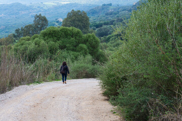 Fototapeta premium Mujer excursionista con mochila en un camino rural