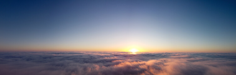 Panorama of sunrise over clouds. Beautiful heavenly landscape.