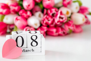 A greeting card for the holiday of March 8 with the number and month on the calendar. Beautiful background of a bouquet of pink tulips. The concept and concept of 
