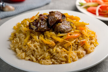 pilaf with beef on white plate close up , uzbek cuisine
